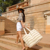Off white soft Jute bag with beige and sage green stripes and flat cotton webbing handle.	This bag is not only practical and stylish but also versatile. It can be used as a beach bag, a shopping bag, weekend bag or even as a stylish tote for everyday use.				

